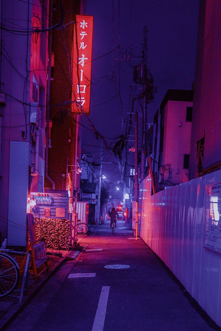 A red neon sign in a dark alleyway - Japan