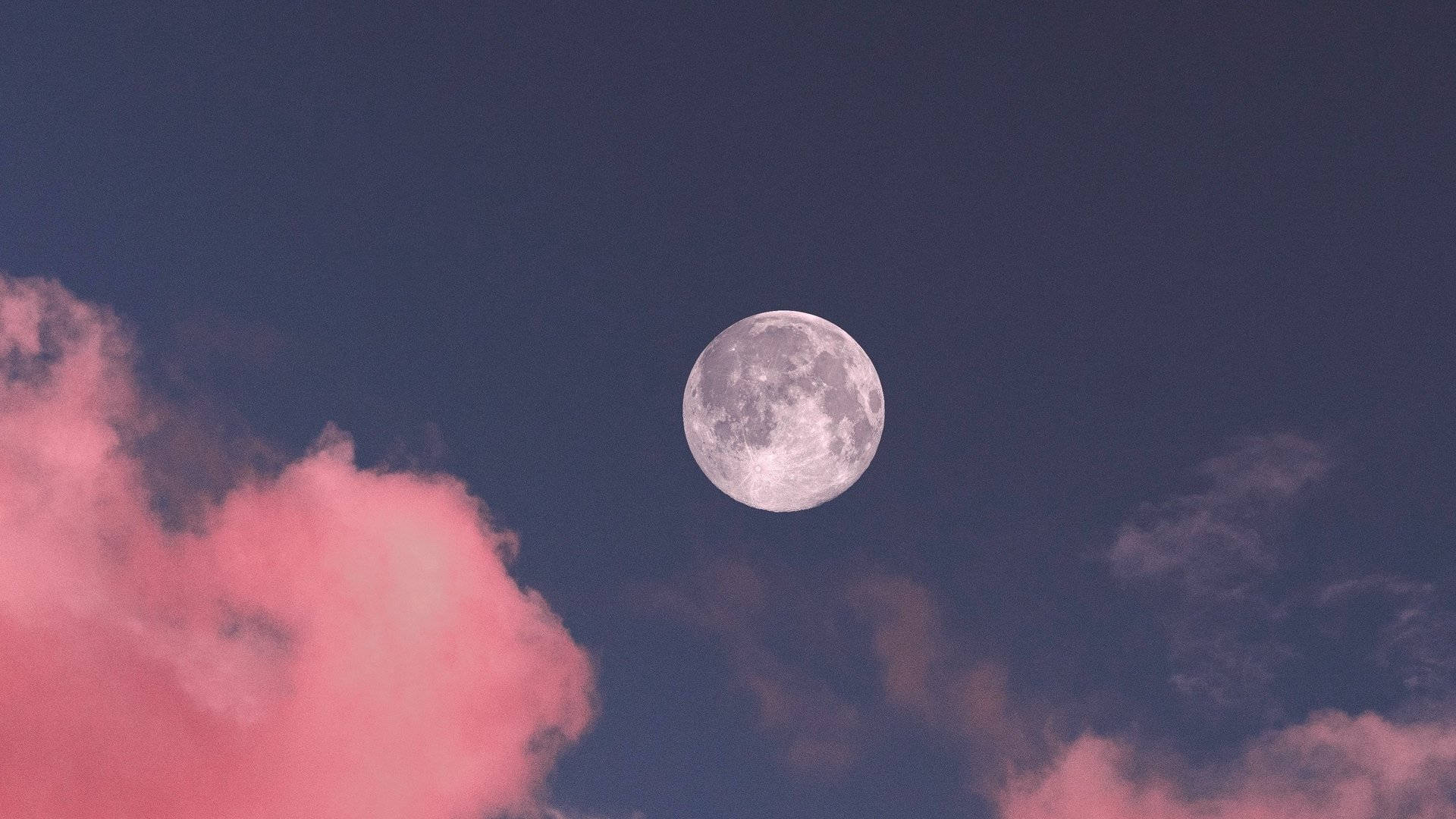 A full moon with pink clouds in the sky. - Moon