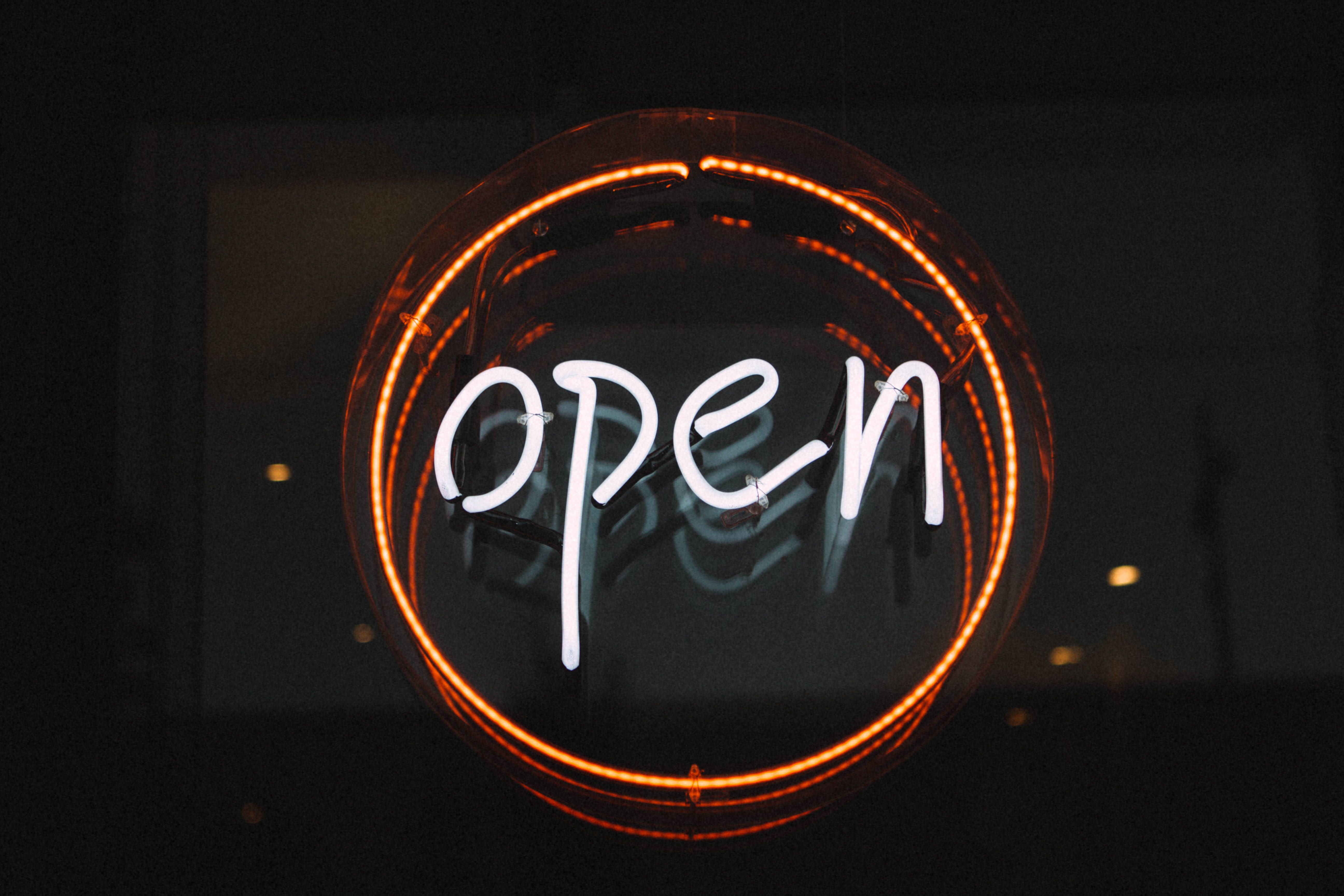 A neon sign that says open - Neon orange