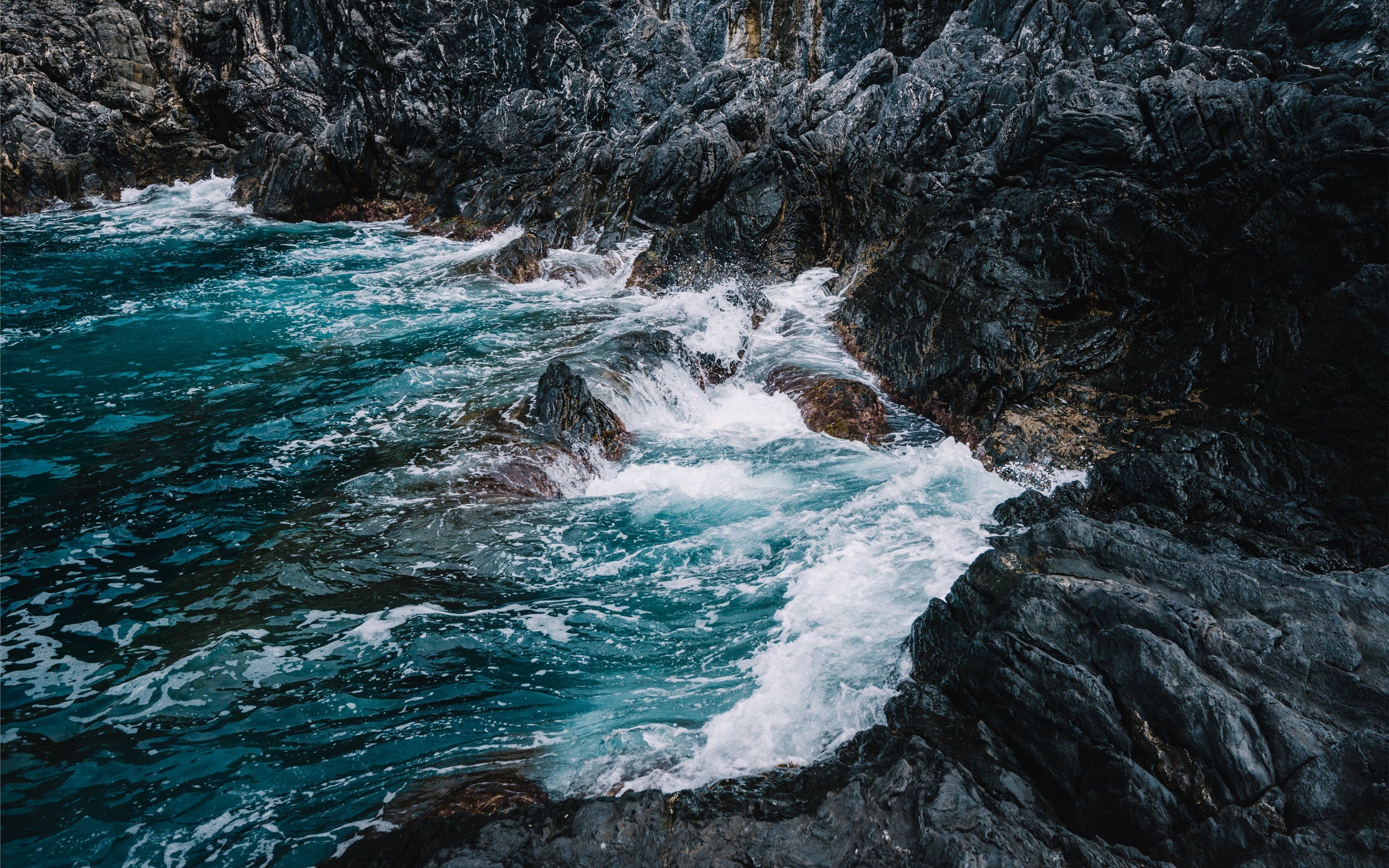A rocky shore with waves crashing against it - Wave