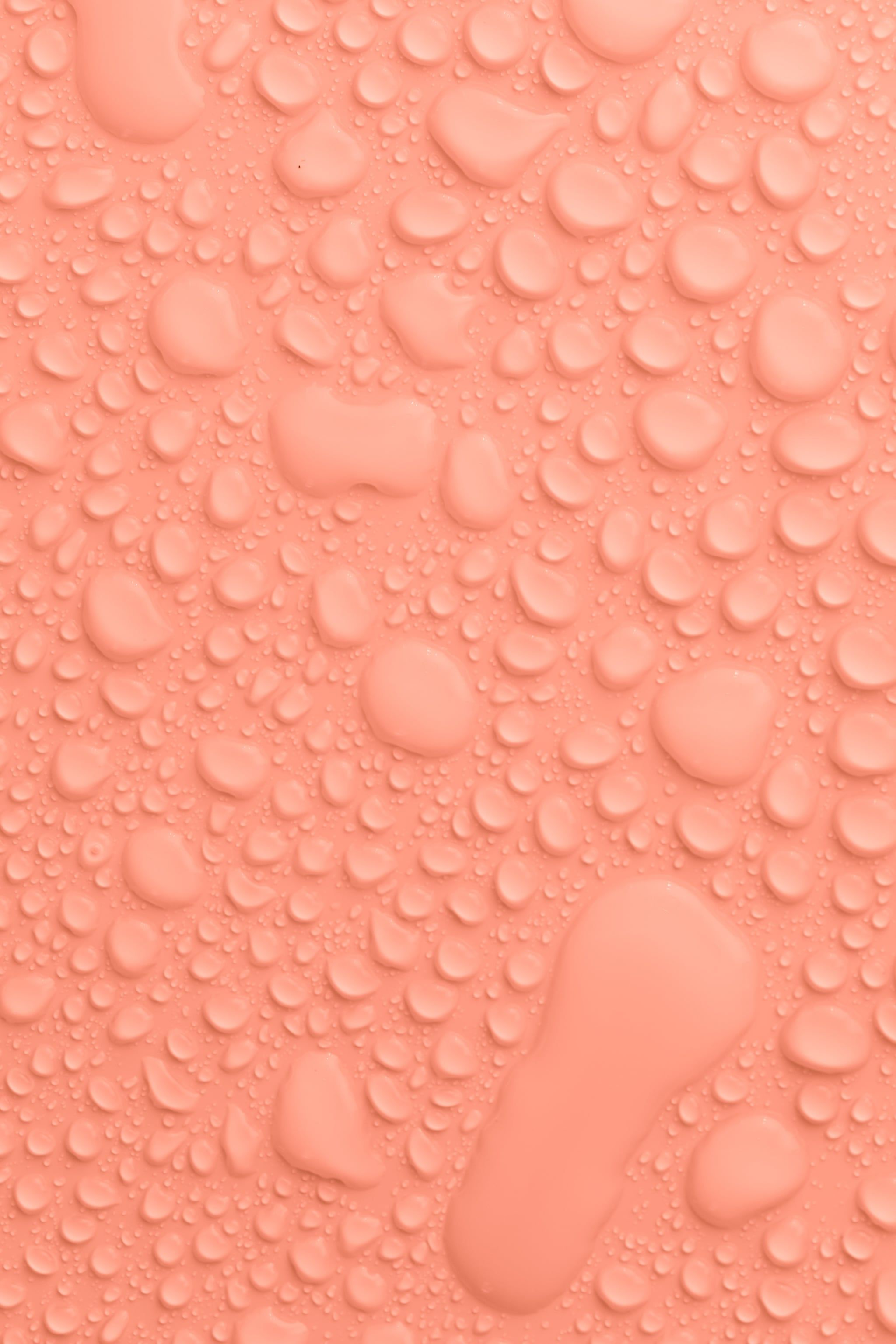 A close up of water droplets on pink background - Peach, orange, water