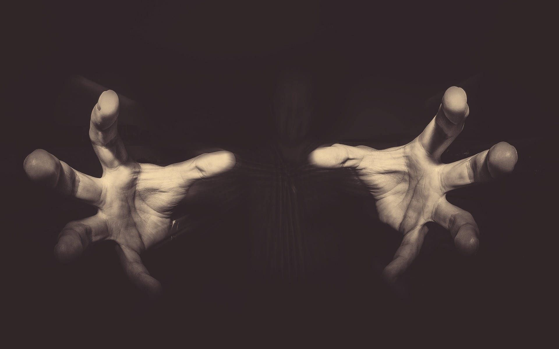 A black and white photo of two hands - Creepy