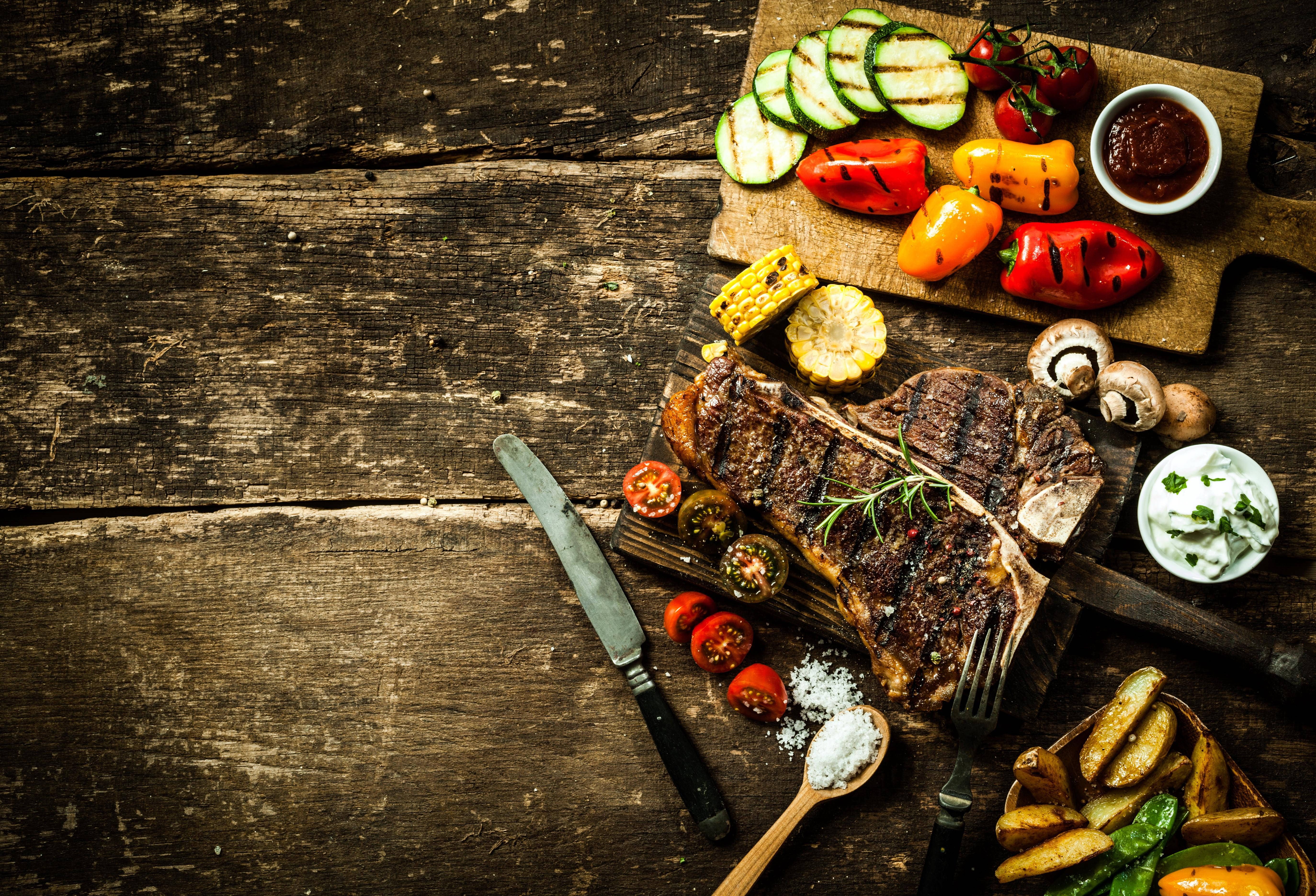 A table with steak, vegetables and condiments - Foodie