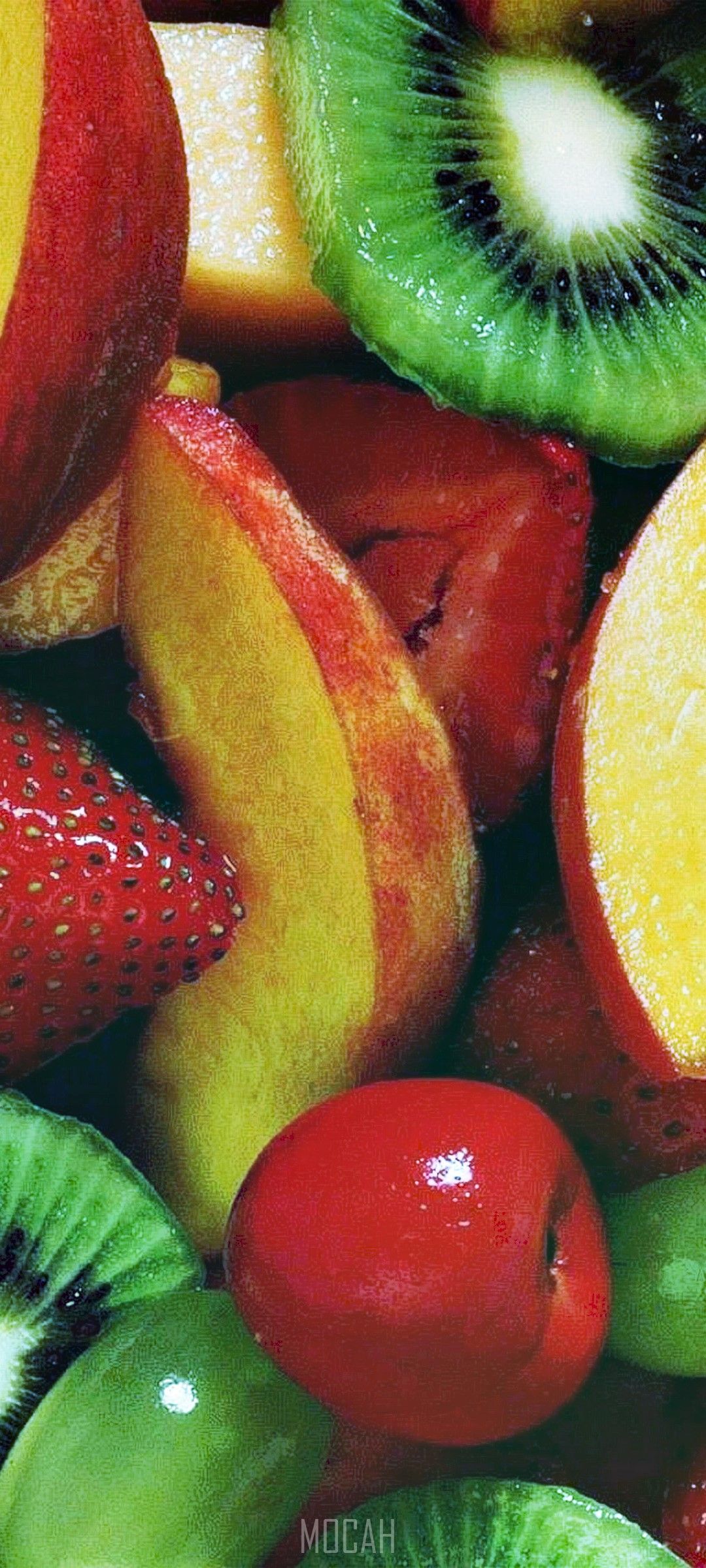 A close up of fruit including kiwi, strawberries, peaches, and oranges. - Foodie