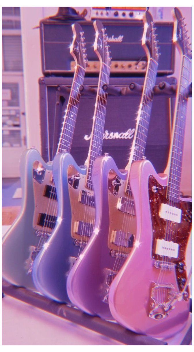 Three guitars are lined up in front of a large amp. - Guitar