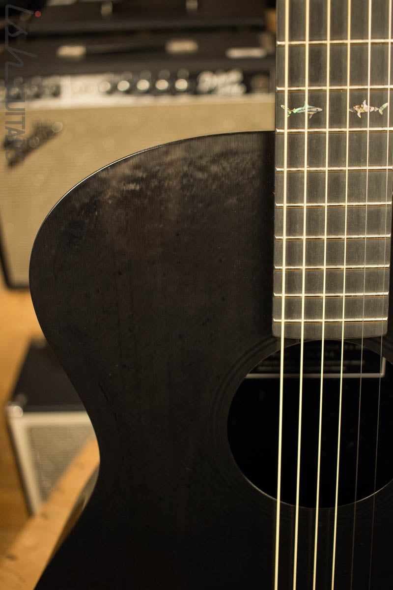 A black guitar with strings and frets. - Guitar