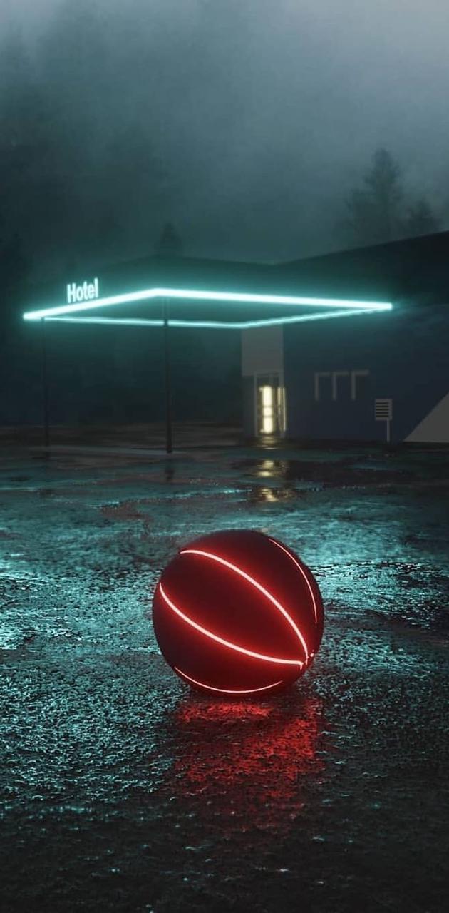 A red neon basketball sits in the rain in front of a motel. - Basketball