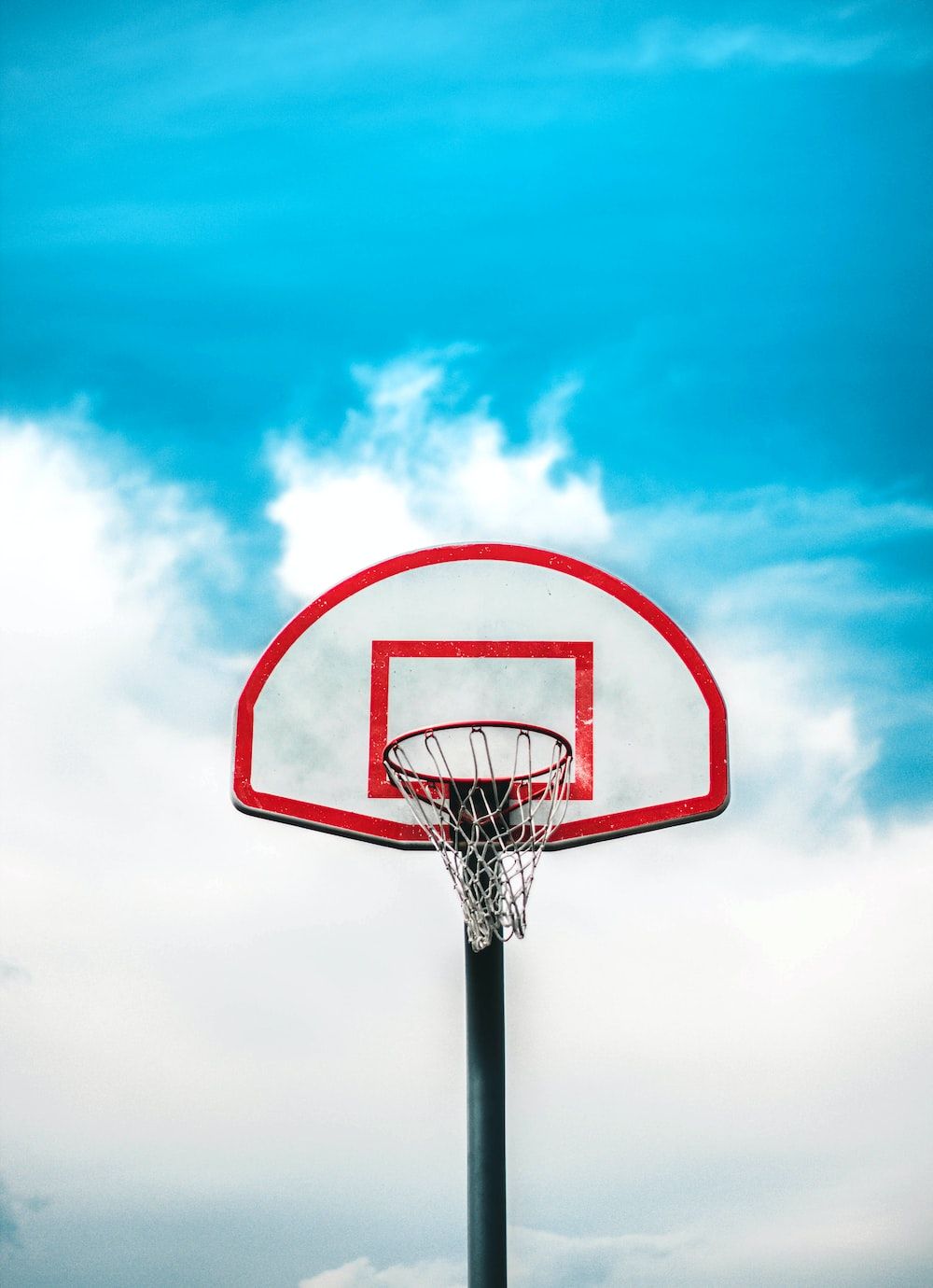 A basketball hoop with a blue sky in the background - Basketball