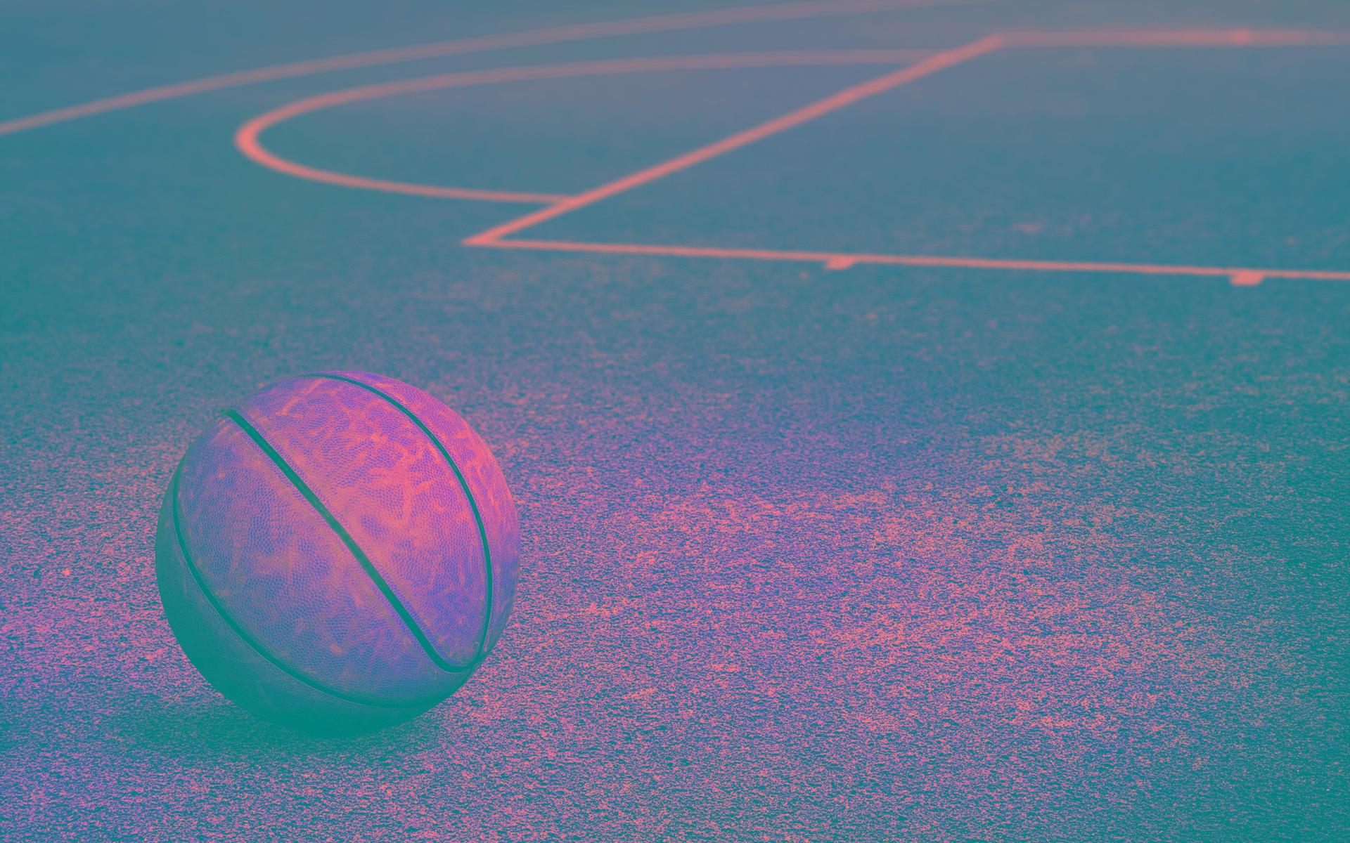 A basketball sitting on the ground in front of an empty court - Basketball