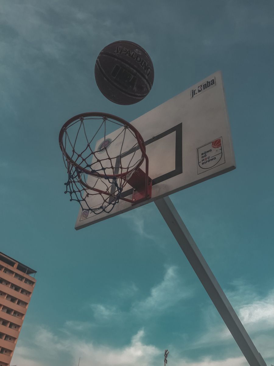 A basketball hoop with the ball in mid air - Basketball