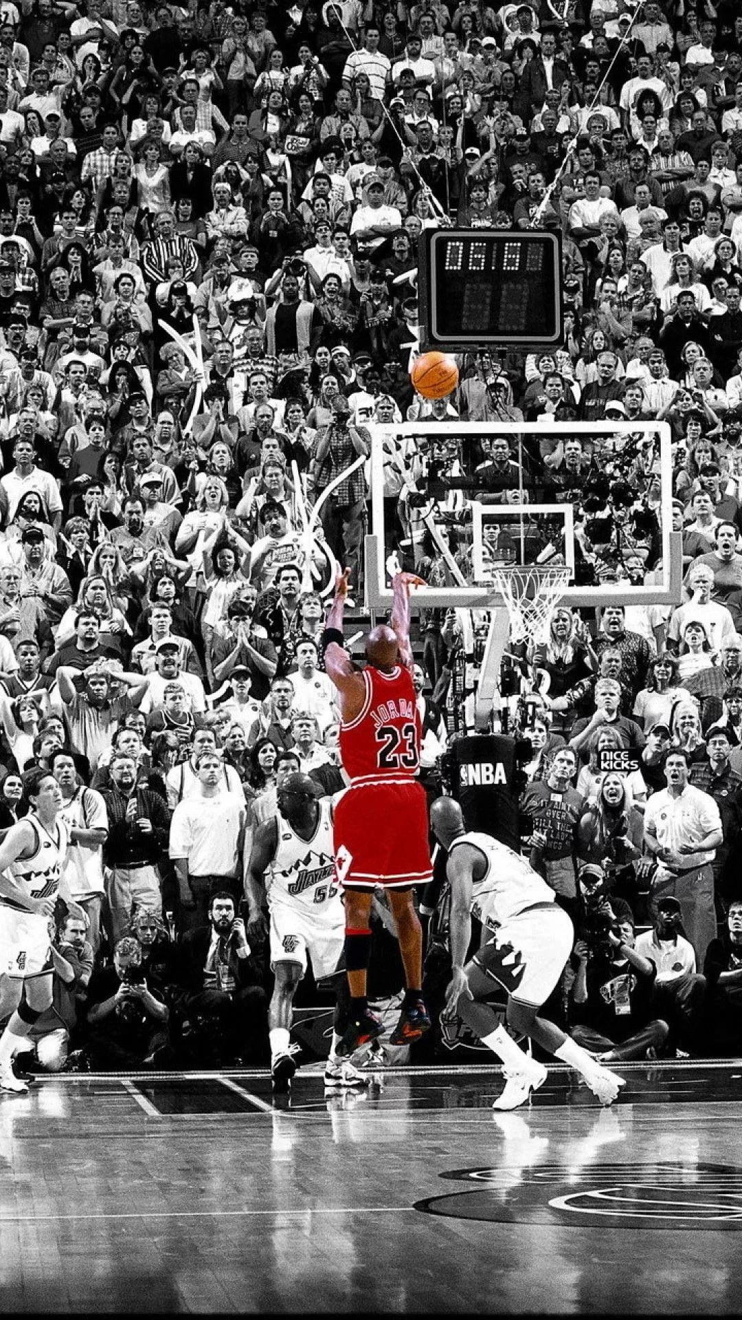 Michael Jordan shot in the air in front of a large crowd. - Basketball
