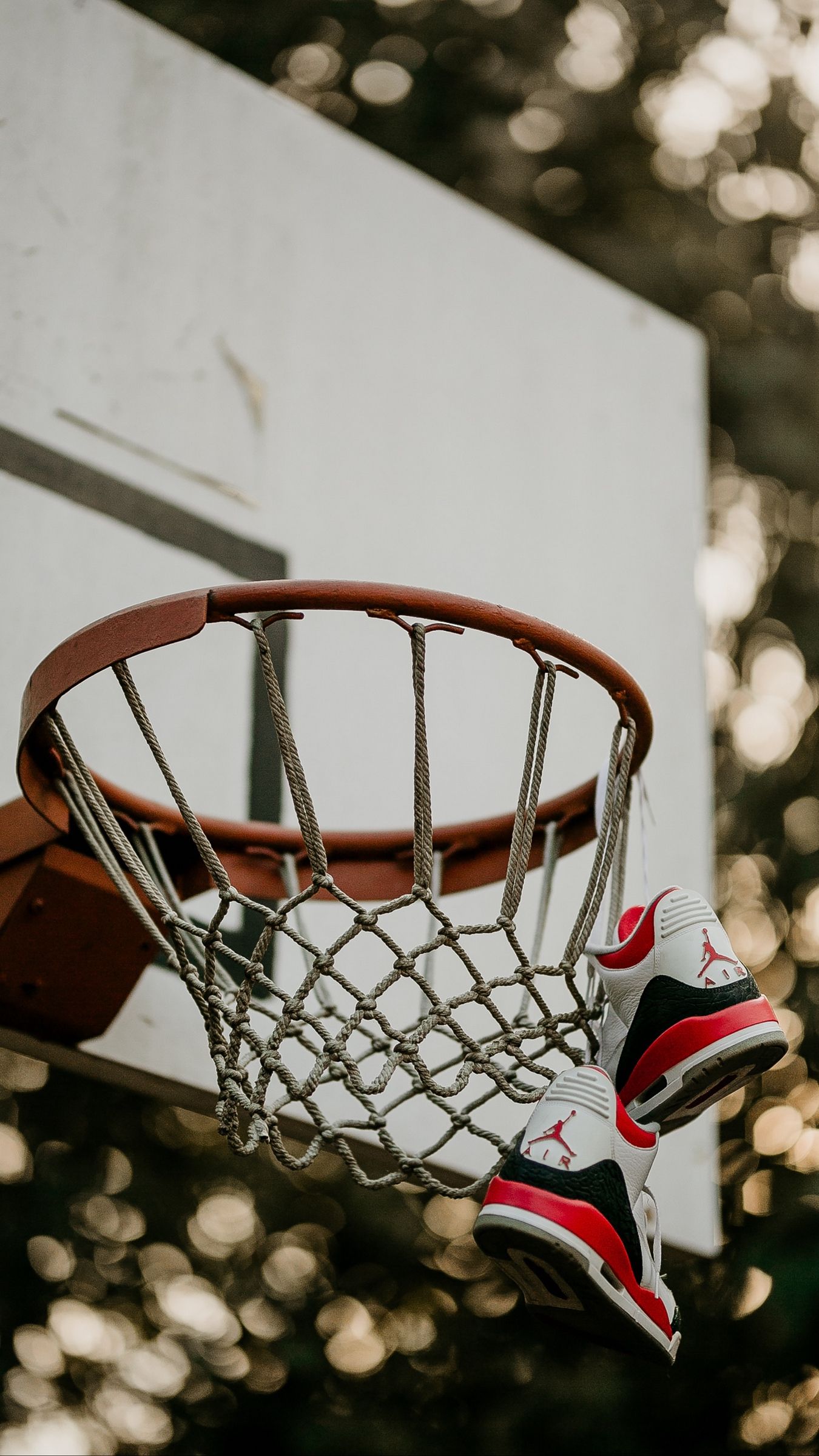 A pair of shoes hanging from the rim - Basketball