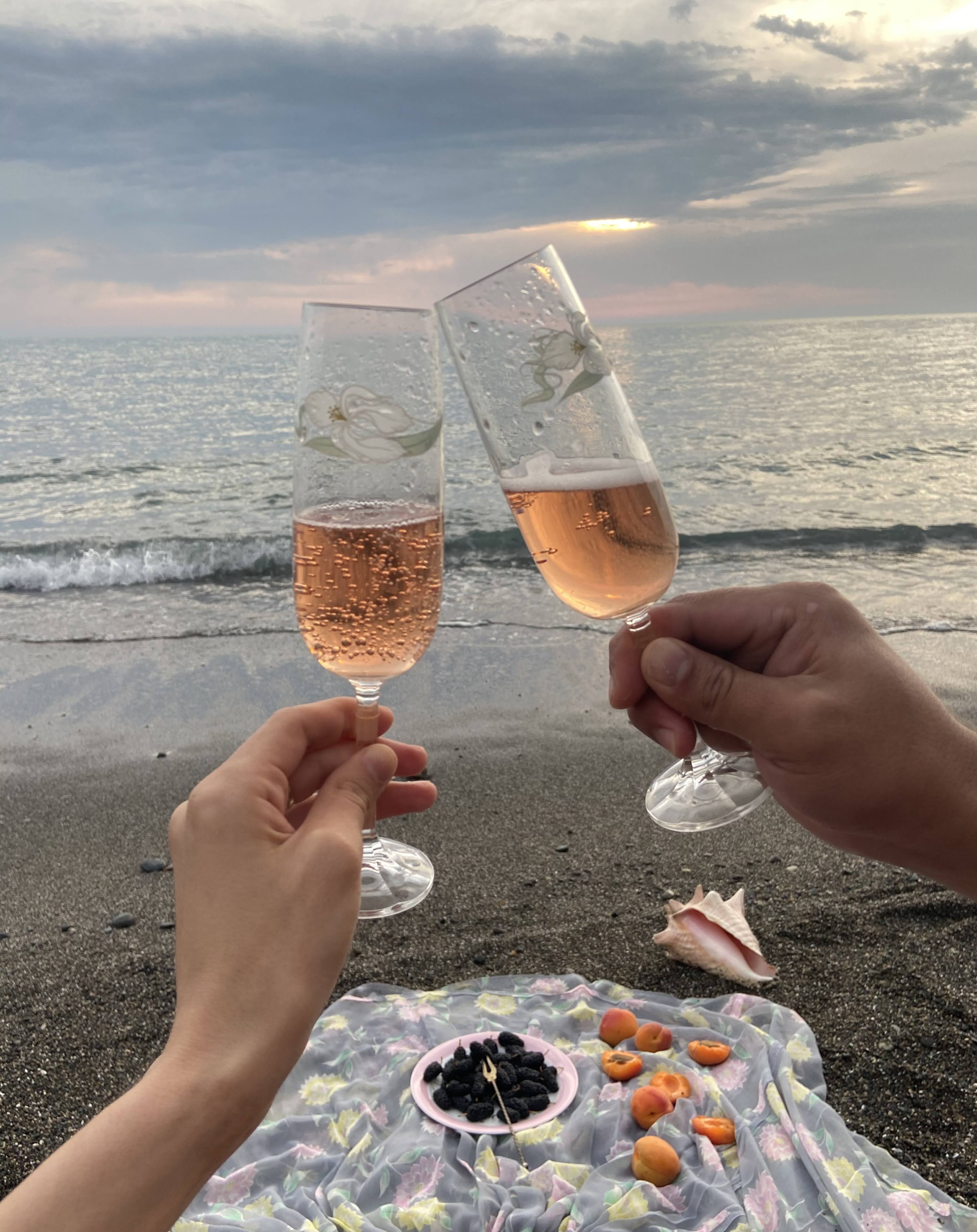 Couple clinking glasses of champagne on seashore · Free