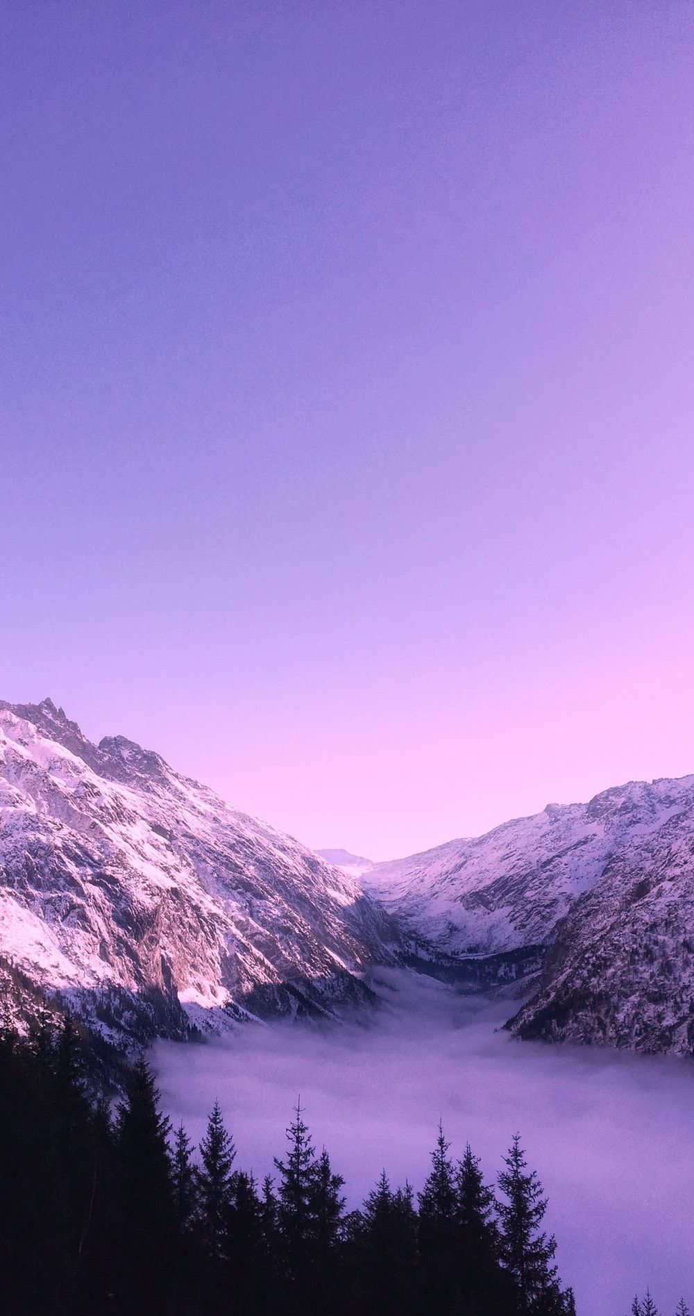 A purple and blue sunset over a snow covered mountain - Nature