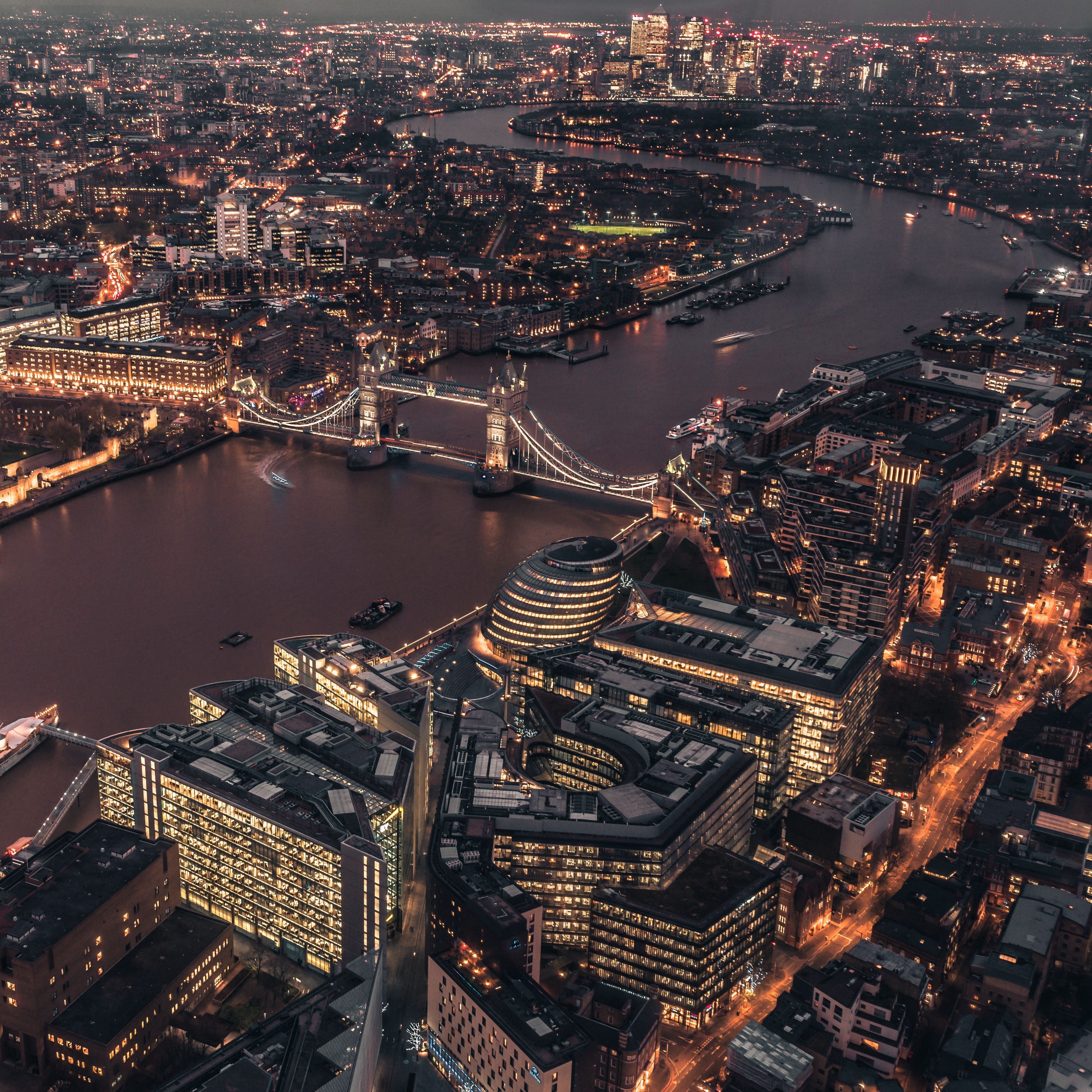 Aerial view of the city of London at night with the Tower Bridge in the background - London