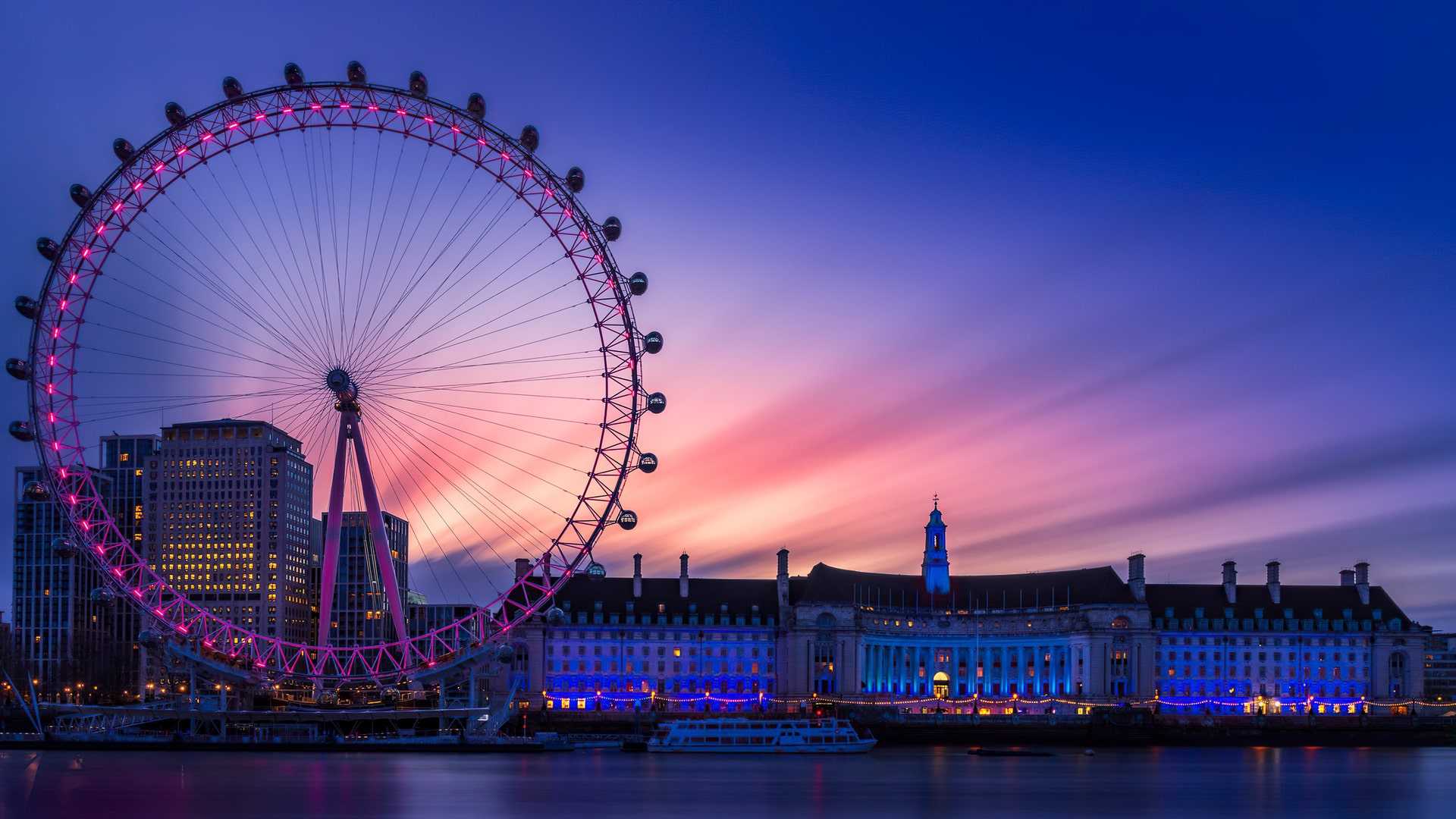 A large ferris wheel in front of the city - London