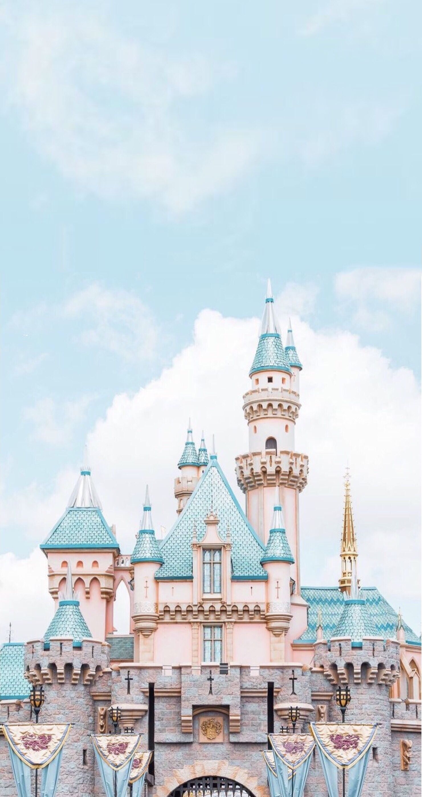 A pink castle with blue roofs and turrets. - Disneyland