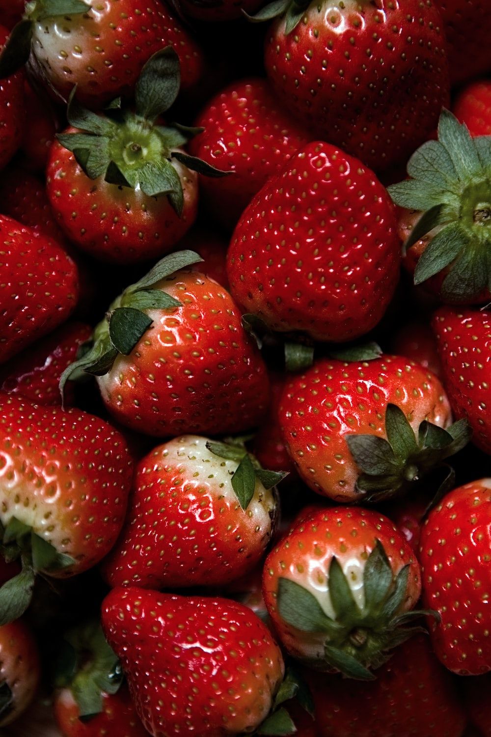 red strawberries on green leaves photo