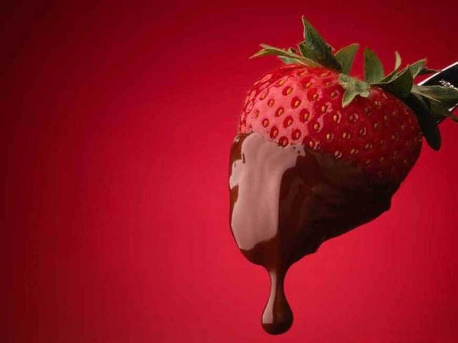 A strawberry being dipped in chocolate - Strawberry