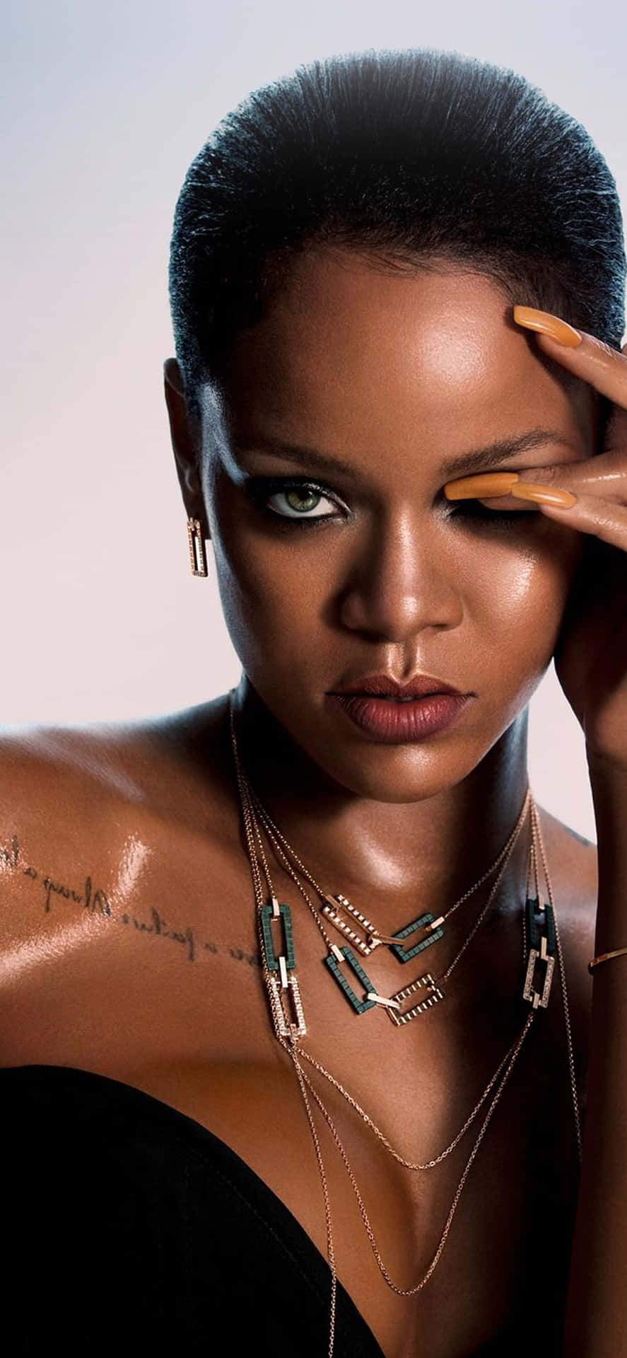 A woman with her hand on the side of here face - Rihanna