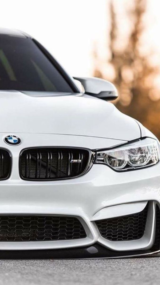 A white BMW M4 with a front end view - BMW