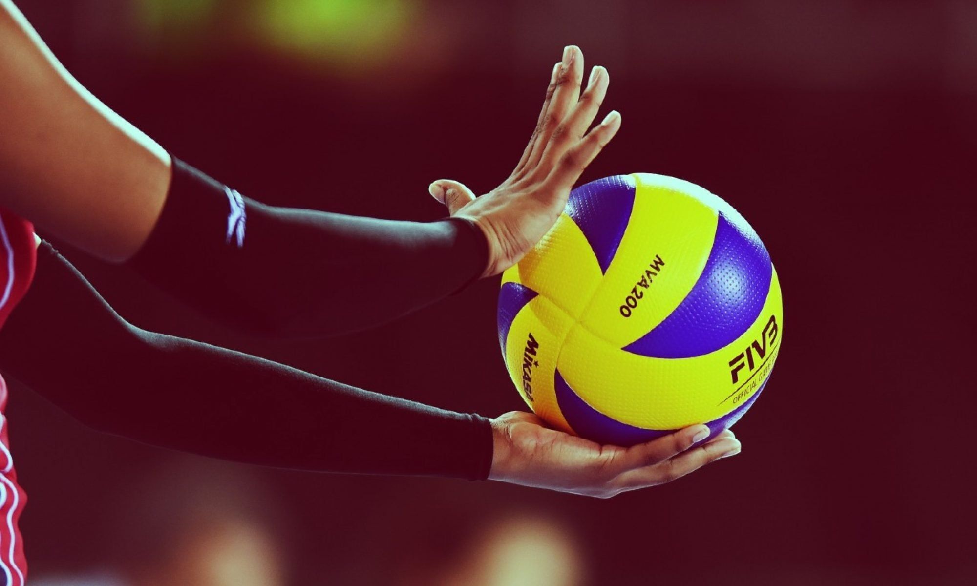 A person holding onto the ball with their hands - Volleyball