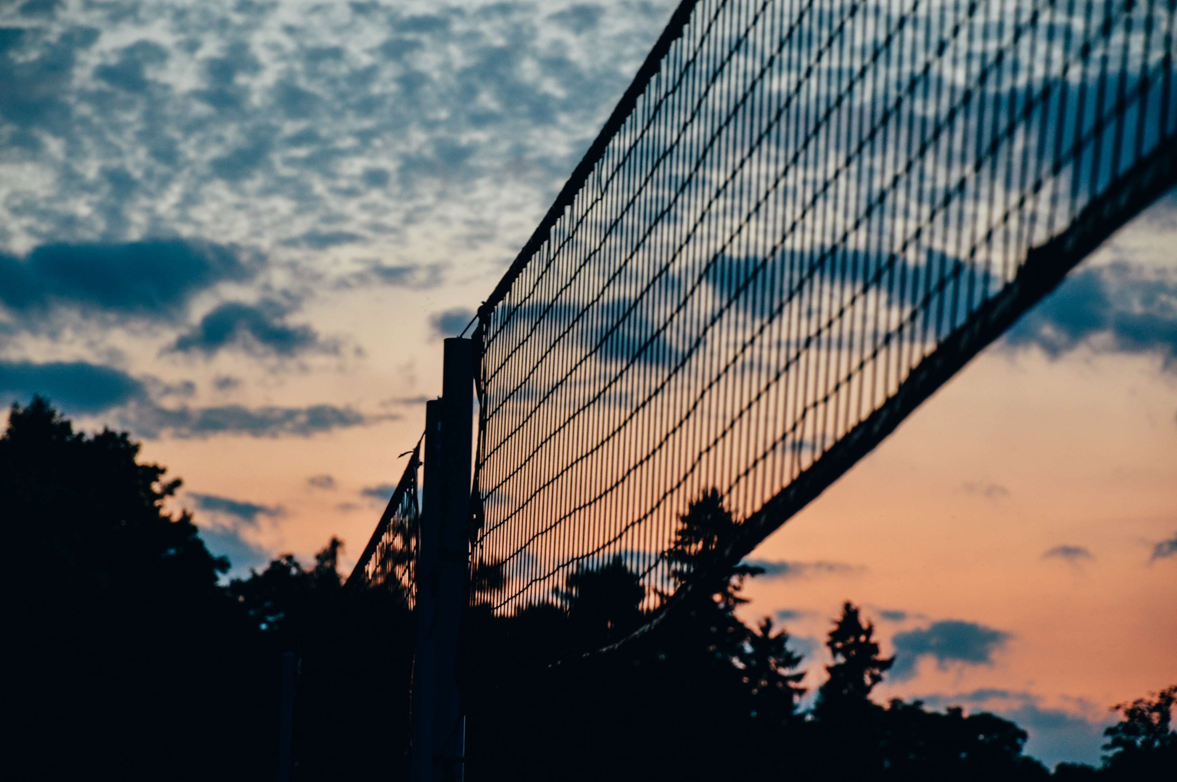 A volleyball net with a beautiful sunset in the background. - Volleyball