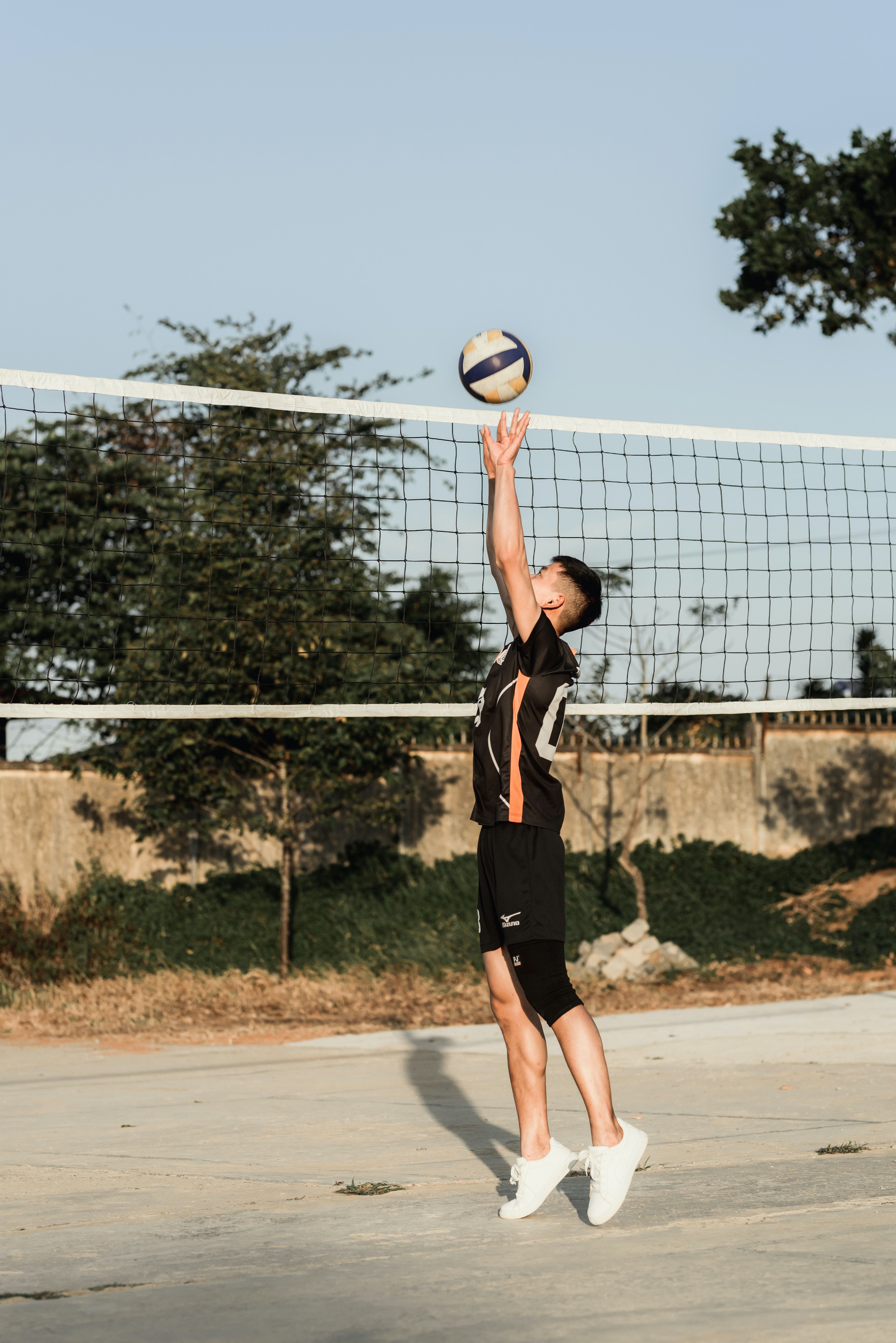 A man in black shirt and shorts playing volleyball - Volleyball