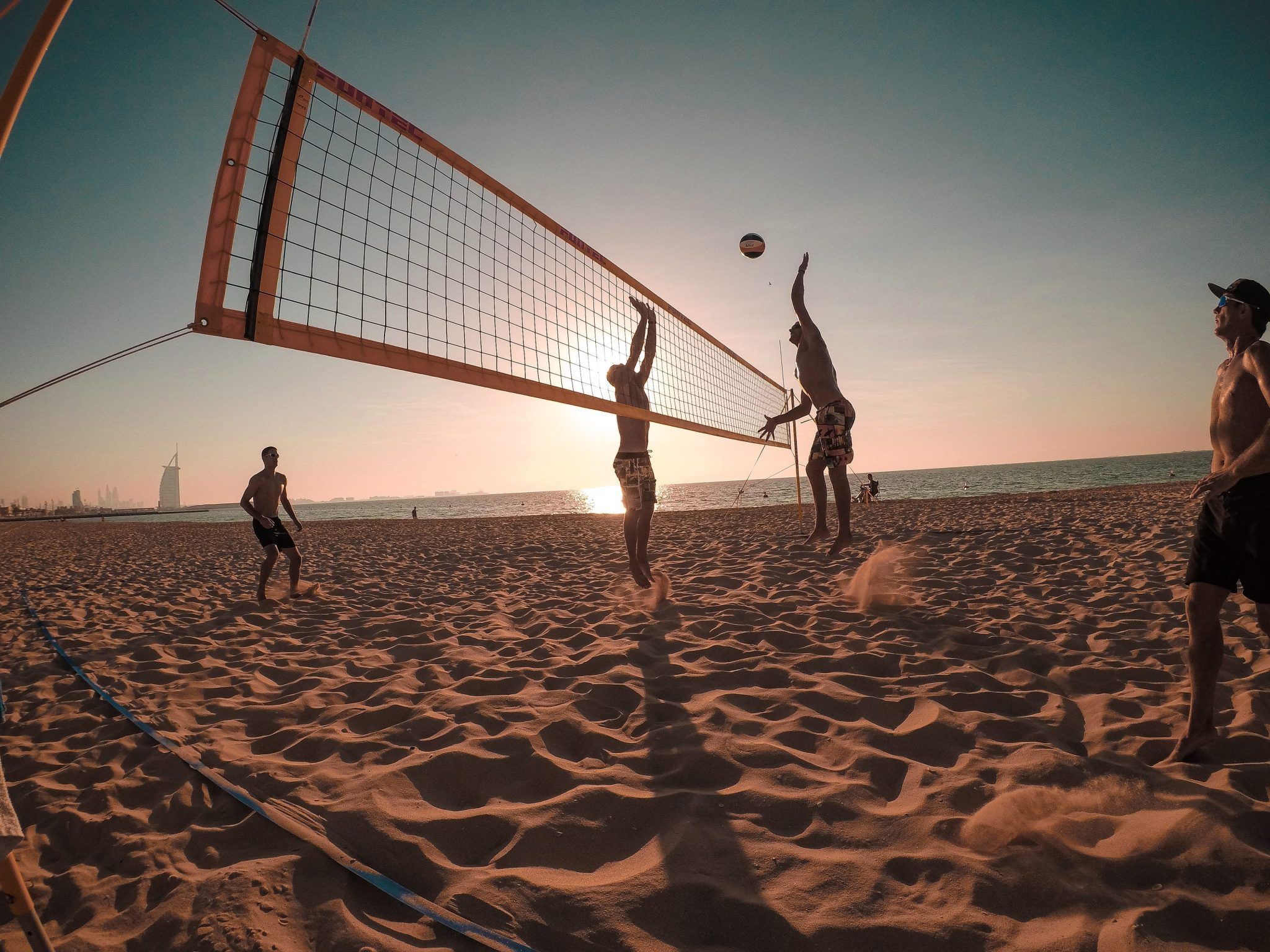 A group of people playing beach volleyball - Volleyball