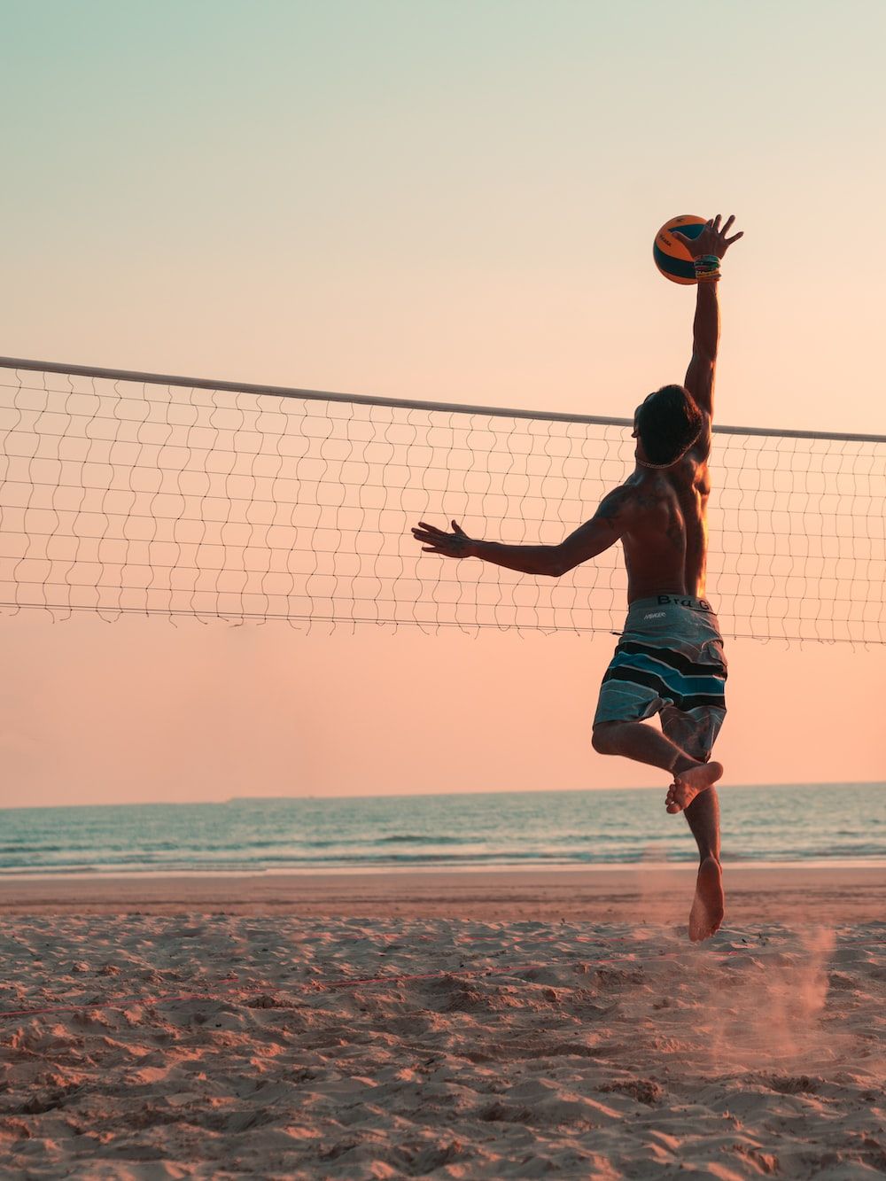 man playing beach volleyball during daytime photo