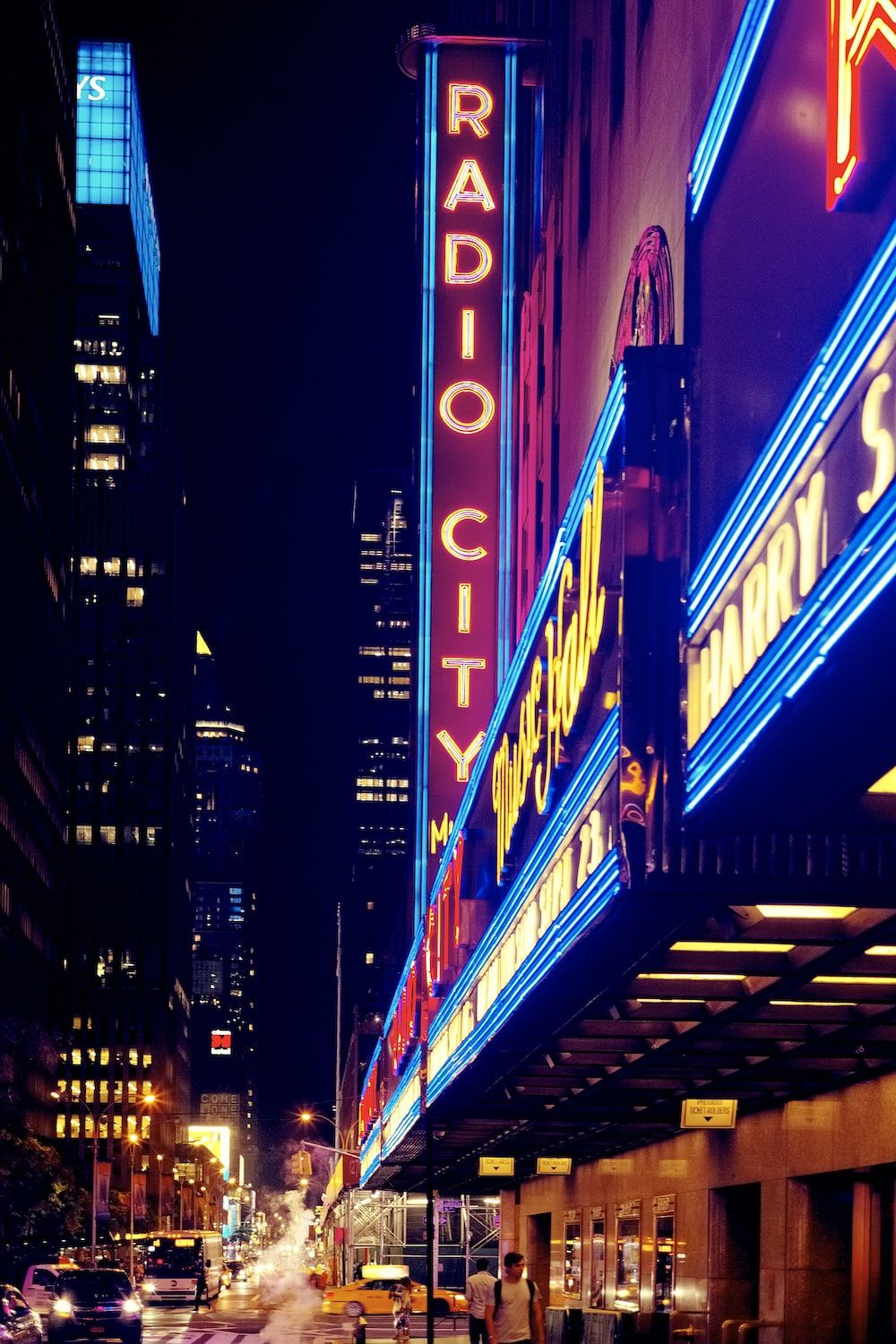 A brightly lit marquee of Radio City Music Hall is seen at night. - City