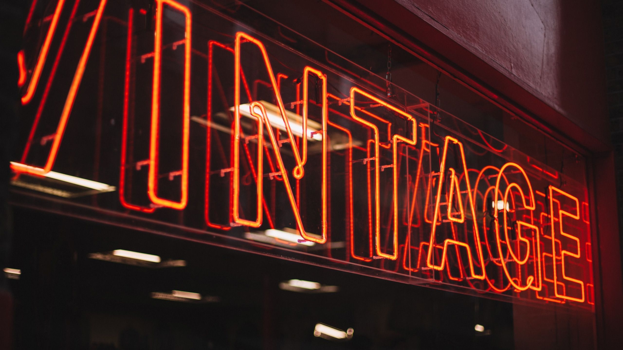 A red neon sign that says 'vintage' in all caps. - Neon orange