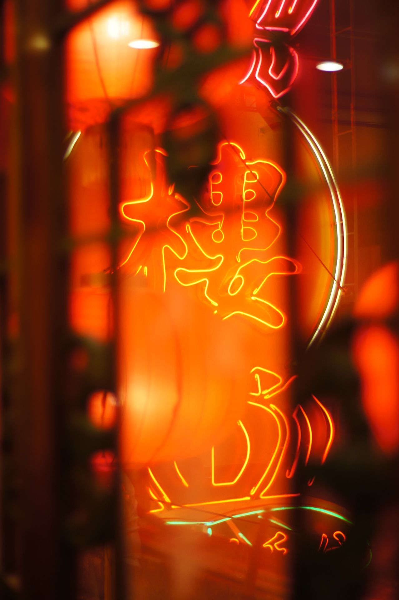 A neon sign of Chinese characters in a red glow. - Neon orange