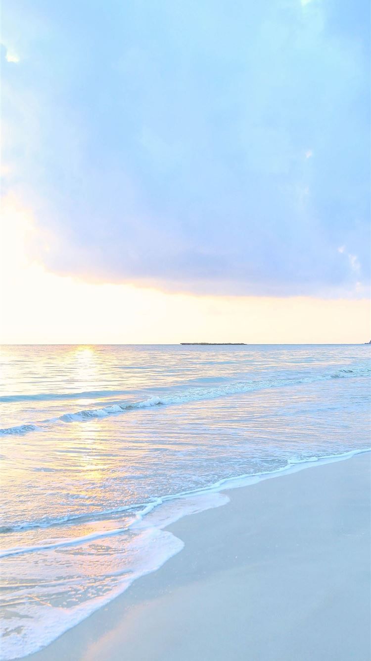 A person walking on the beach with their surfboard - Hawaii