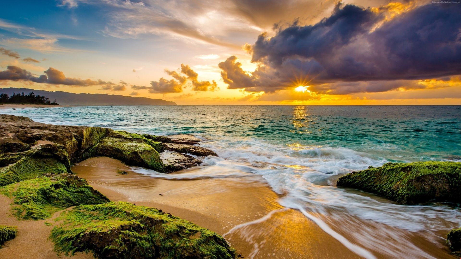 A sunset on the beach with waves crashing - Hawaii