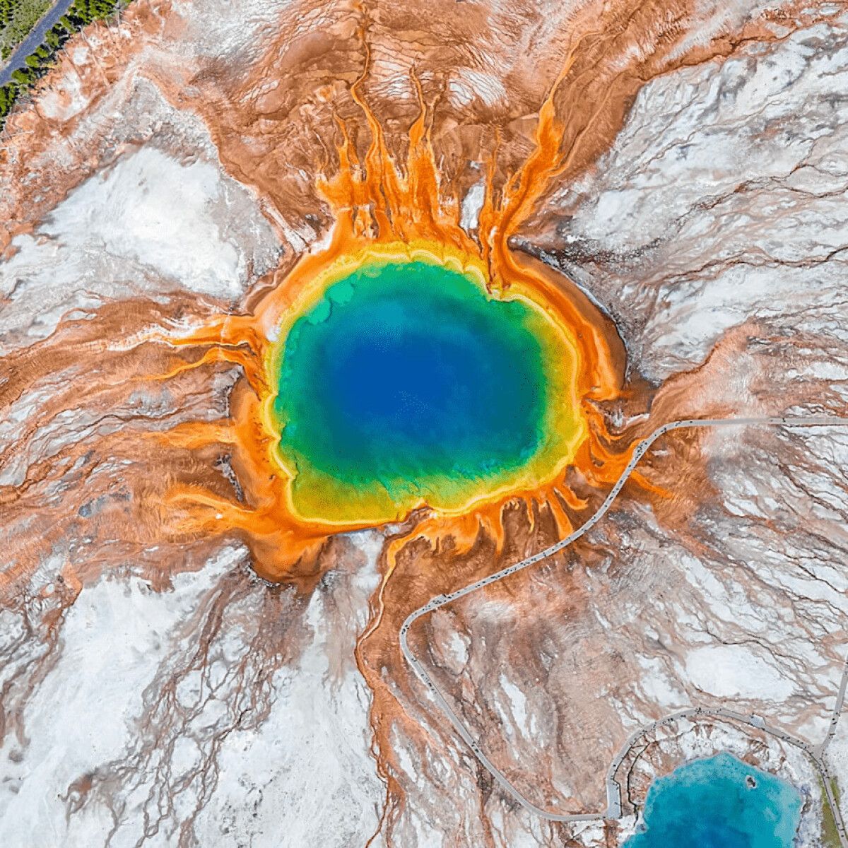 Aerial view of the Grand Prismatic Spring in Yellowstone National Park, showing the vivid colors of the thermal pool and surrounding landscape. - Earth