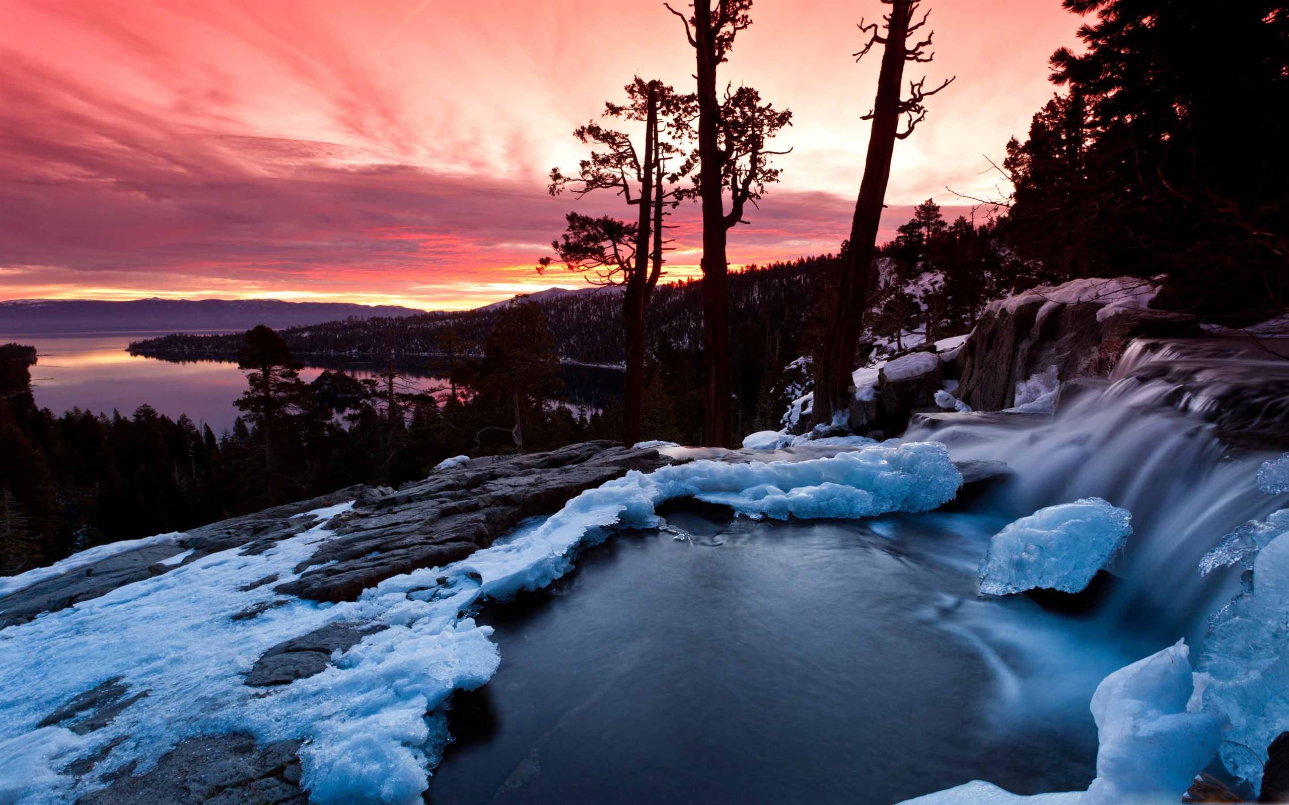 A waterfall is flowing over rocks in the snow - California