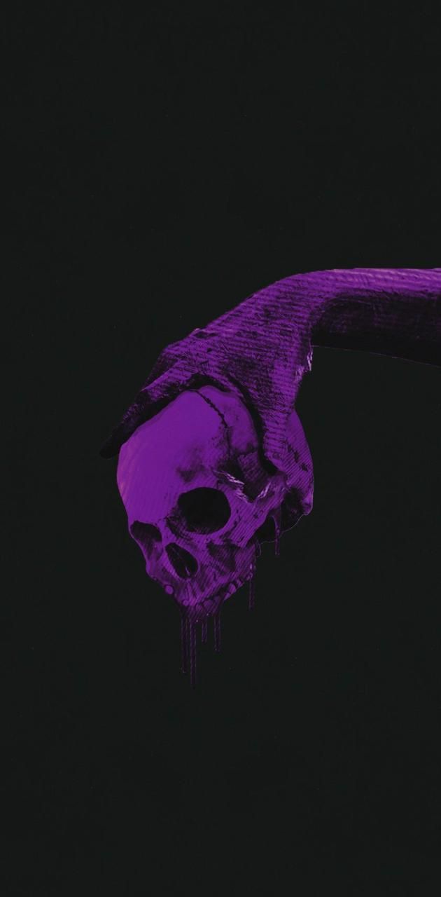 A purple skeleton hand holding a purple skull in the dark - Skull