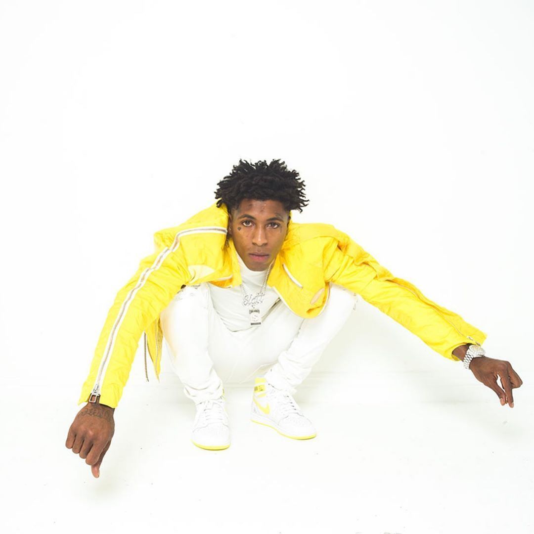 NBA YoungBoy in a yellow jacket and white pants - 