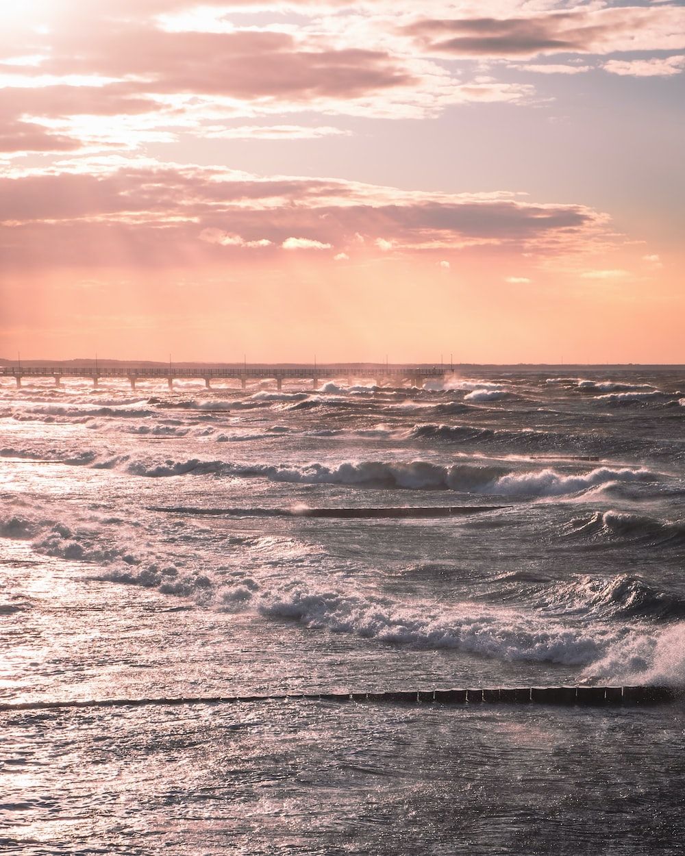 sea waves crashing on shore during sunset photo