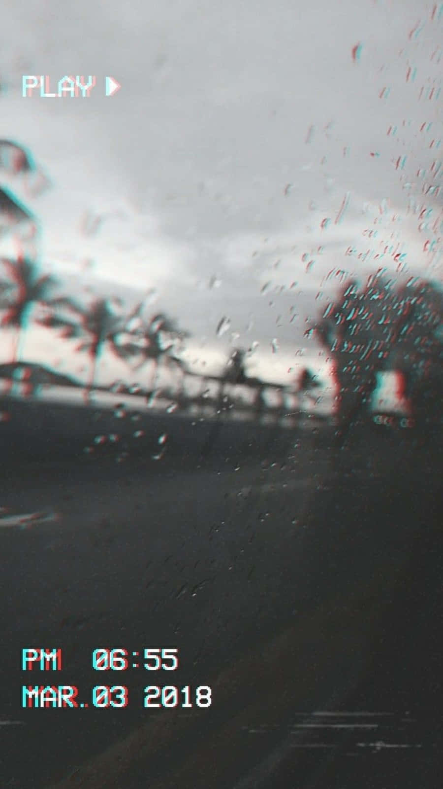 Raindrops on a windshield with a video play screen on the bottom left - VHS, rain