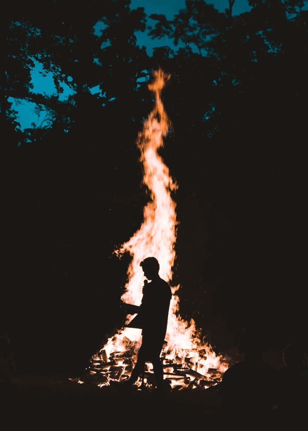 A man standing in front of a fire - Fire
