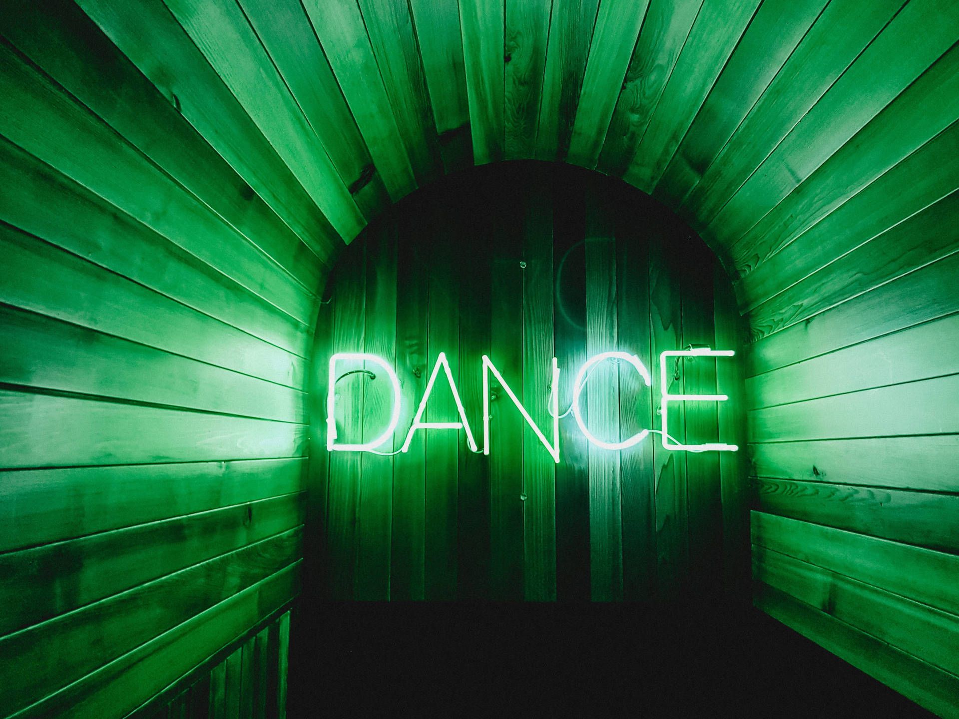 A neon sign that says dance - Neon green