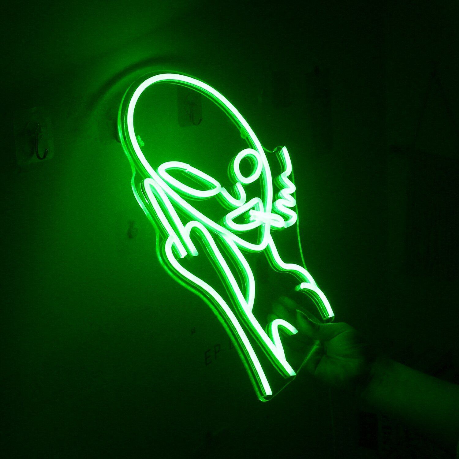 A neon sign of a shoe with a green background - Neon green