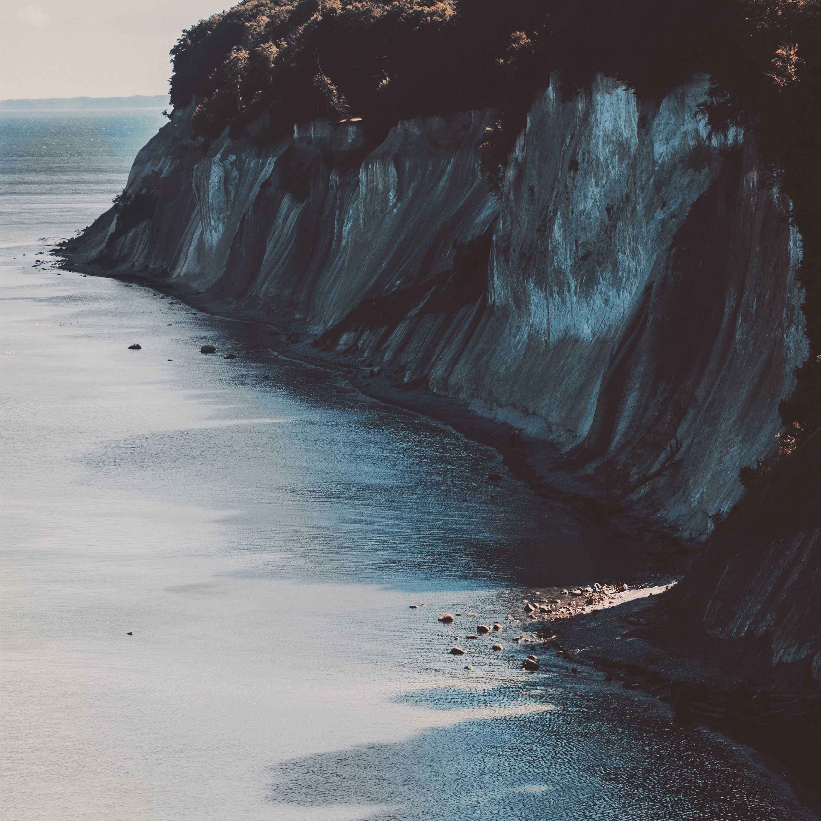 A rocky cliff overlooking a body of water. - Ocean, coast