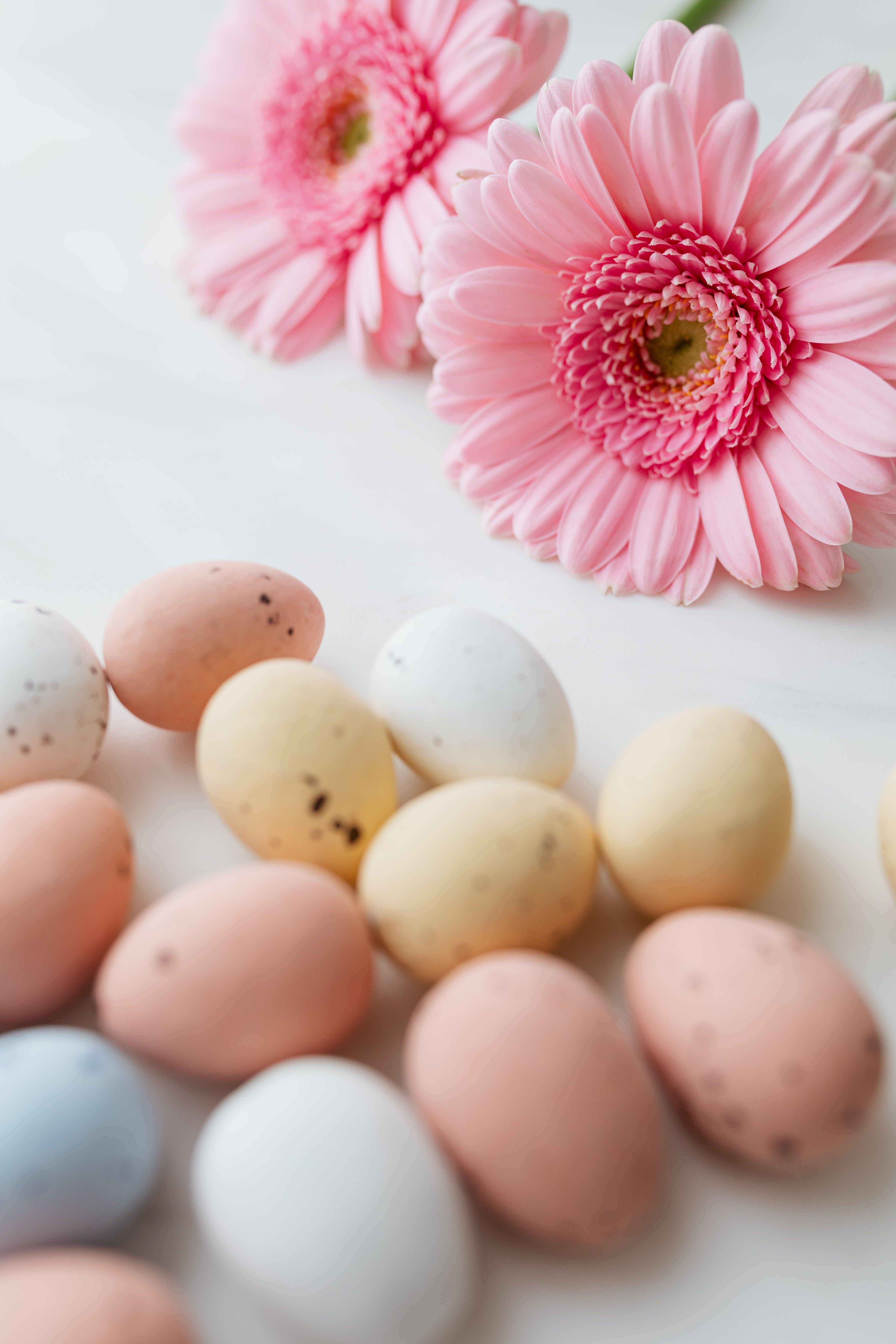 A table with eggs and pink flowers on it - Easter