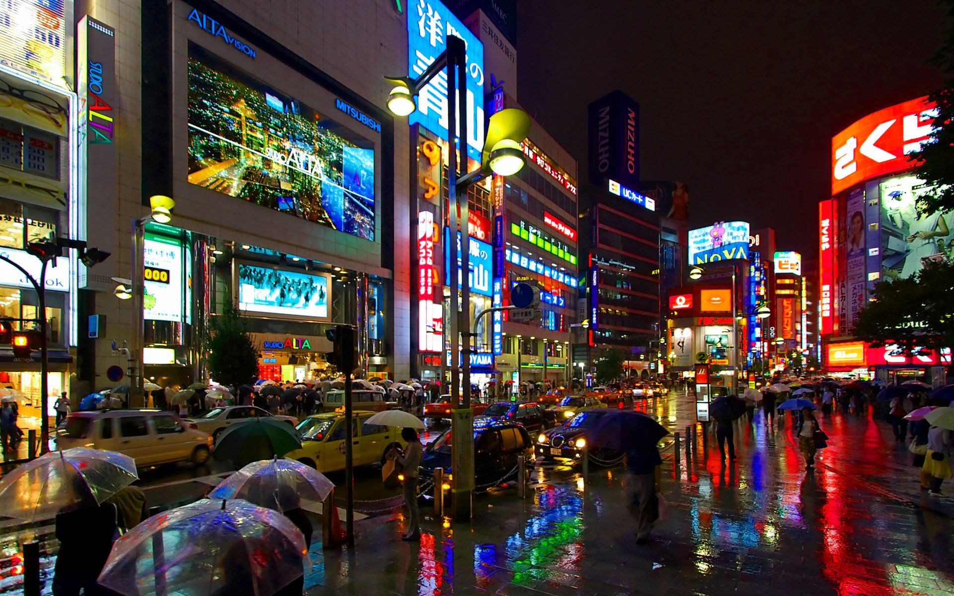 People walking down a busy street at night with many lit signs. - Tokyo, Japan, cityscape