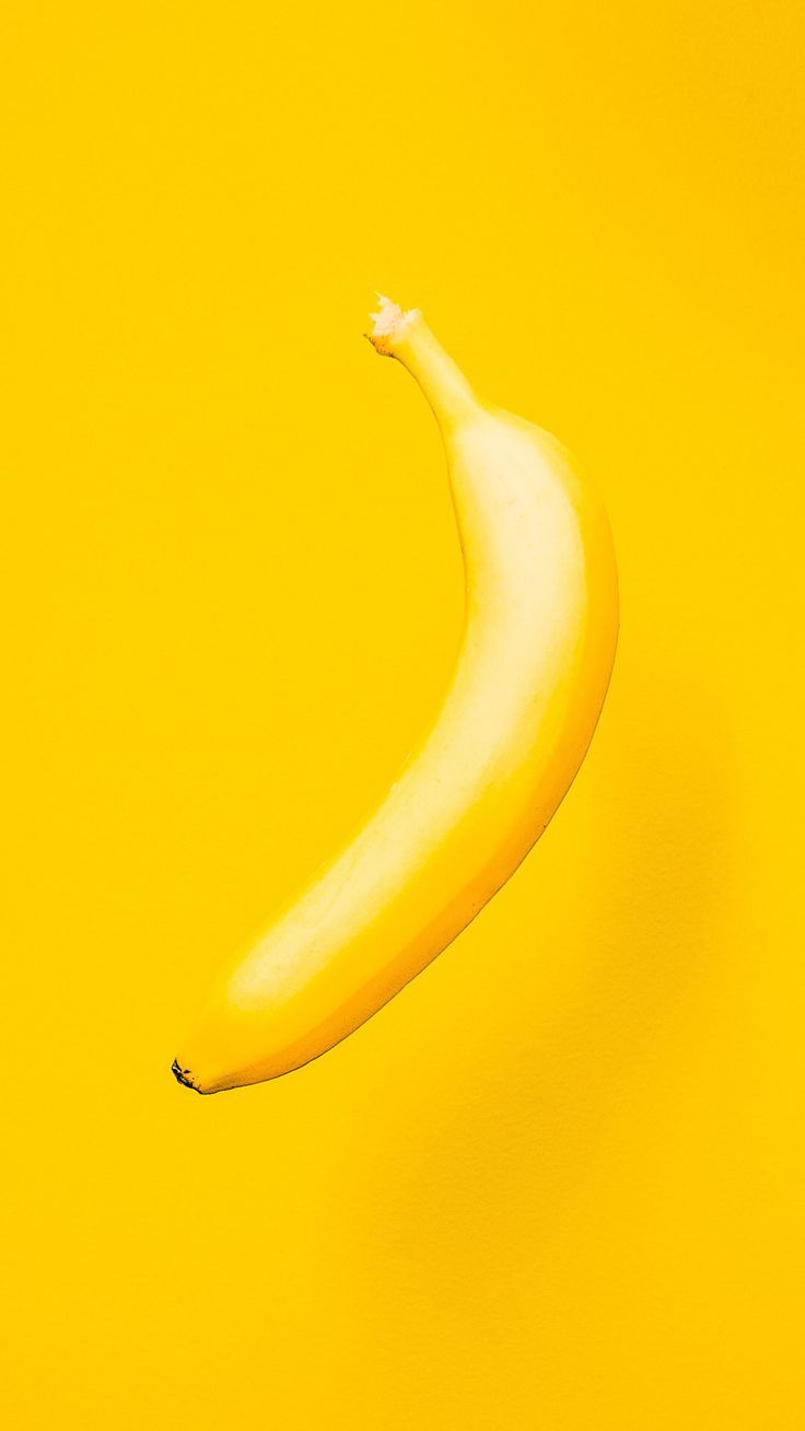 A yellow banana on a yellow background - Banana