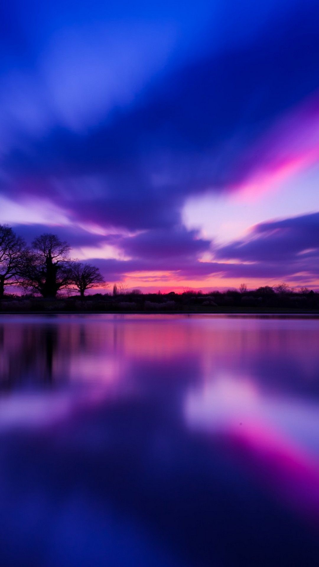 A sunset over the water with trees in it - Cute purple