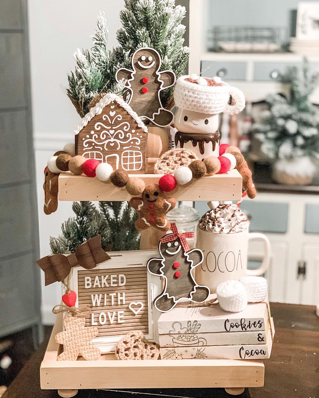 A wooden tiered tray with gingerbread decorations and a sign that says 